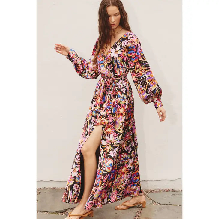 loral print maxi with a surplice neckline, flowy skirt, self sash tie, and long cuffed bubble sleeves. Luxuriously lined and made from 100% polyester. And that slit