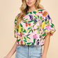 Introducing the Resort Cutie Top: a vibrant and playful addition to your wardrobe. This abstract printed top boasts short balloon sleeves and a flattering dropped shoulder design, perfect for any occasion. With a back keyhole and button closures, it's effortlessly stylish and easy to wear. Order yours today!