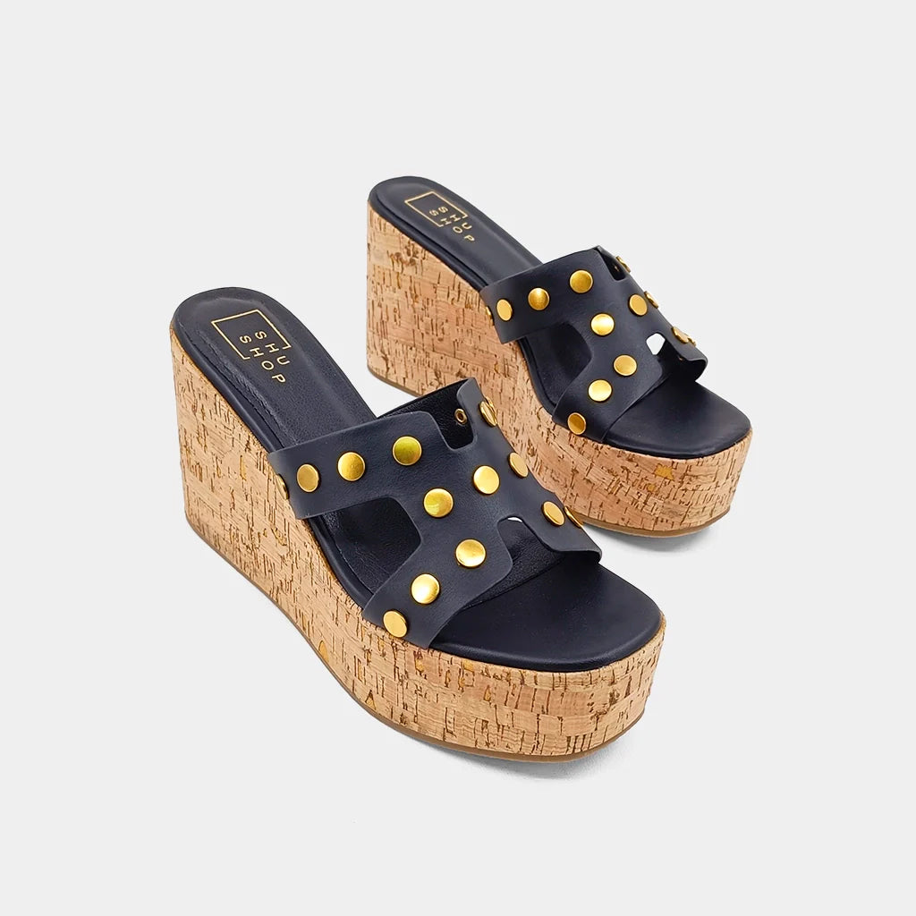 JORDANA wedges are crafted from luxurious faux leather, soft and buttery to the touch, with a unique texture accompanied by antique-looking gold studs, adding a touch of elegance and modern flair. The delicate yet sturdy straps are designed to provide both style and support, while the comfortable cork platform soles make them ideal for enjoying long summer days in both fashion and comfort.